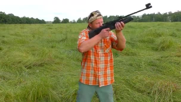 Hunter en gorra y gafas de sol apuntando a un arma — Vídeos de Stock