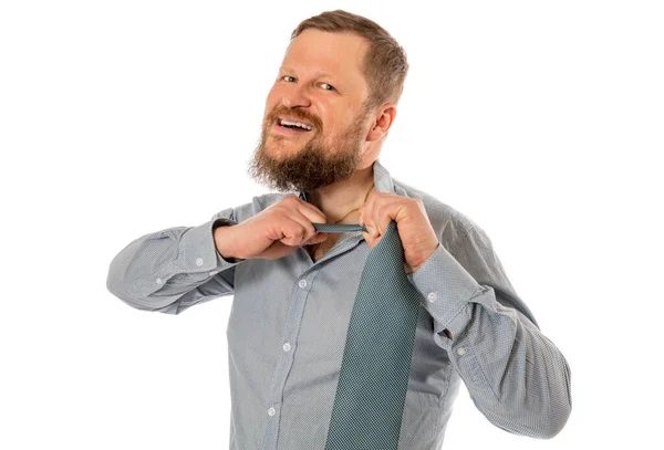 Χαρούμενος γενειοφόρος άντρας ντυμένος με πουκάμισο σκίζει τη γραβάτα του. — Φωτογραφία Αρχείου