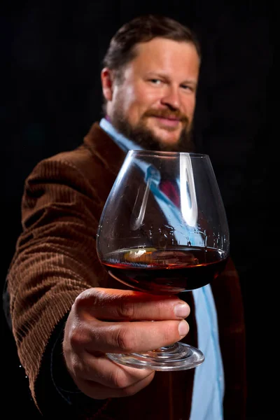 Elegante uomo barbuto vestito con giacca marrone con bicchiere di whisky — Foto Stock