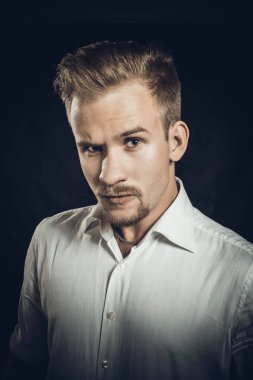 Beyaz gömlekli genç adam stüdyo resmi.