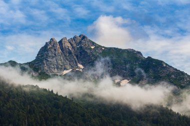 Kafkasya dağlarının manzarası, dağların tepesinde bulutlar.