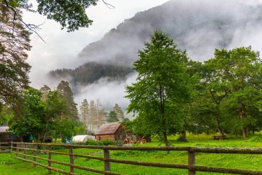 Çiftlik ve bulutlu dağlarla güzel bir manzara