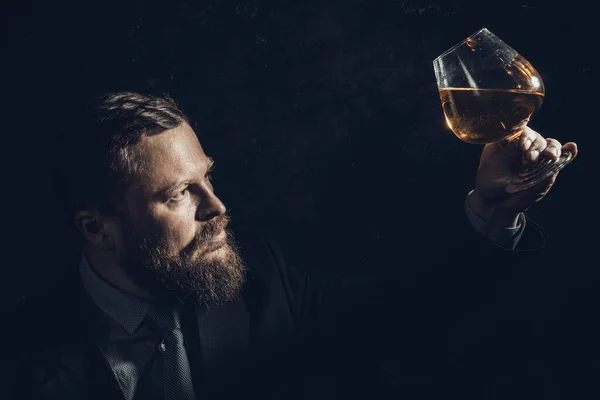 Solide homme barbu confiant en costume avec verre de whisky — Photo