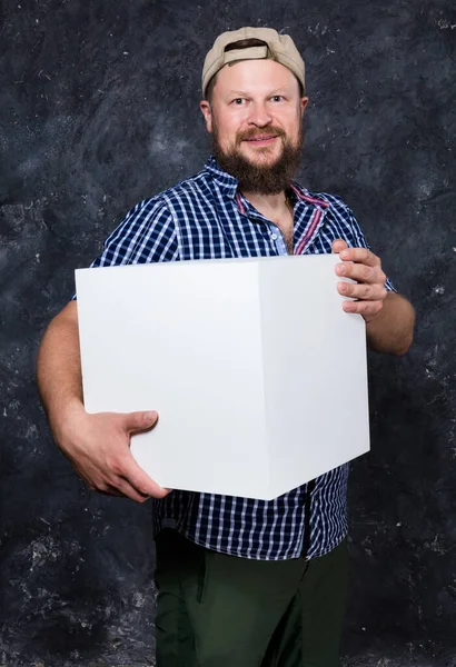 Homem barbudo alegre na camisa com objeto do cubo do blanc para seu logotipo — Fotografia de Stock