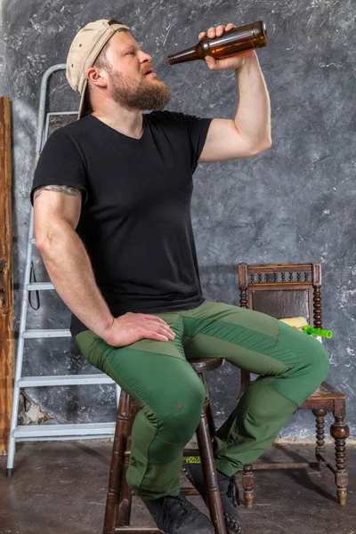 Fröhlicher bärtiger Polier macht Pause mit Flasche Bier — Stockfoto