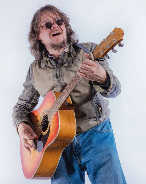 Mature musician plays acoustic guitar studio portrait. Stock Image