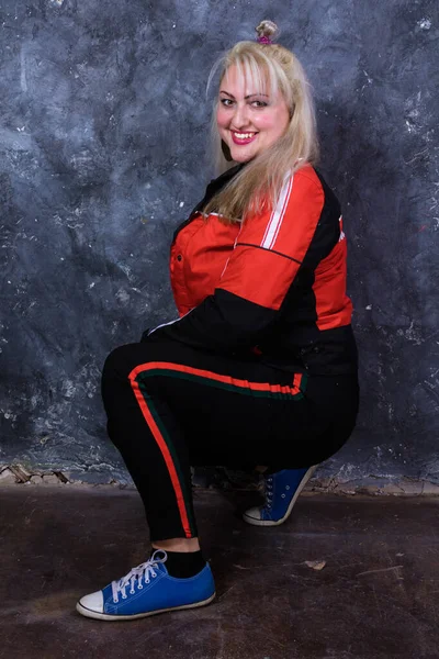 Spor tarzı giyinmiş çekici, tombul bir kadın.