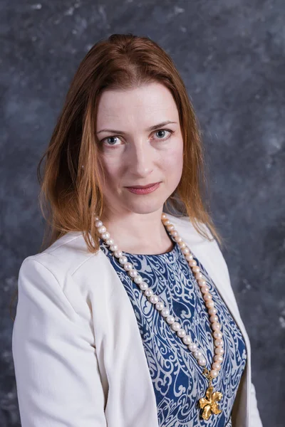 Mujer alegre de mediana edad en vestido azul y chaqueta blanca — Foto de Stock