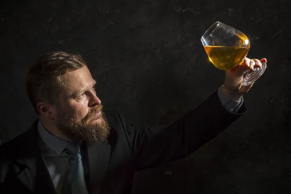 Stevige zelfverzekerde man met baard in pak met glas whisky — Stockfoto