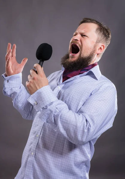 Bärtiger emotionaler Sänger mit Mikrofon im Shirt-Studio-Porträt. — Stockfoto