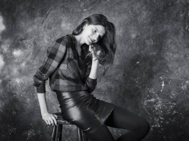 Deri etekli güzel bir kadının stüdyo portresi.