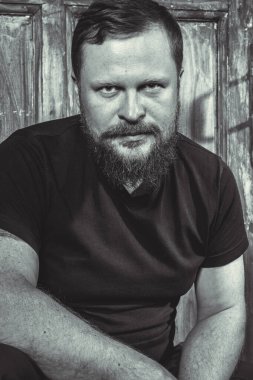 Olgun sakallı adam klasik kapının arkasında oturuyor.