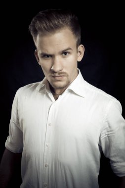 Beyaz gömlekli genç adam stüdyo resmi.