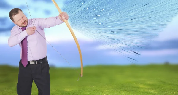 Geschäftsmann beim Bogenschießen mit grünem Feld im Hintergrund — Stockfoto