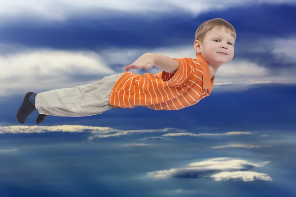 Młody chłopiec latający z chmura niebo w tle — Zdjęcie stockowe