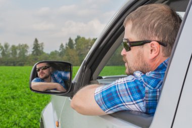 Arabada oturan adam.