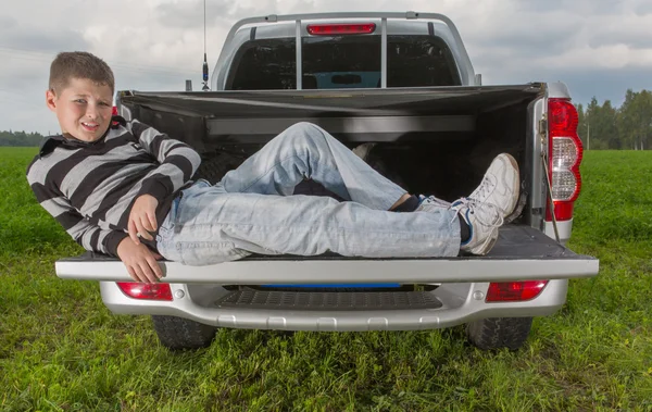 Jongen auto kofferbak opleggen — Stockfoto