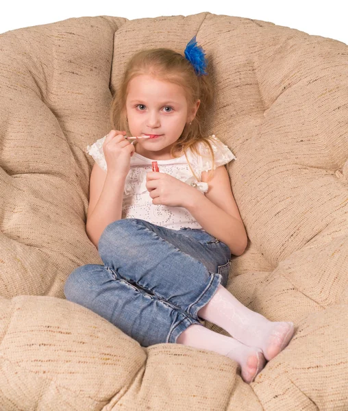 Little girl sitting in armchair