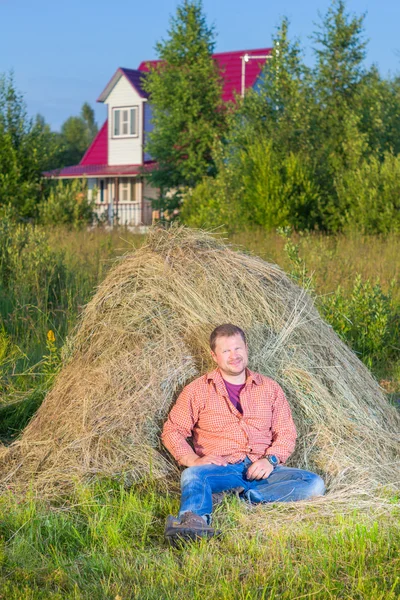 Деревенский человек возле стога сена — стоковое фото