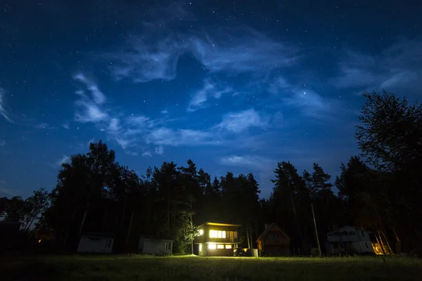 Yö kohtaus pieni mökki ja tähdet taivaalla — kuvapankkivalokuva