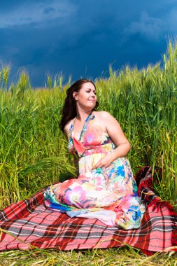 Ekose çavdar alanı üzerinde oturan kadın
