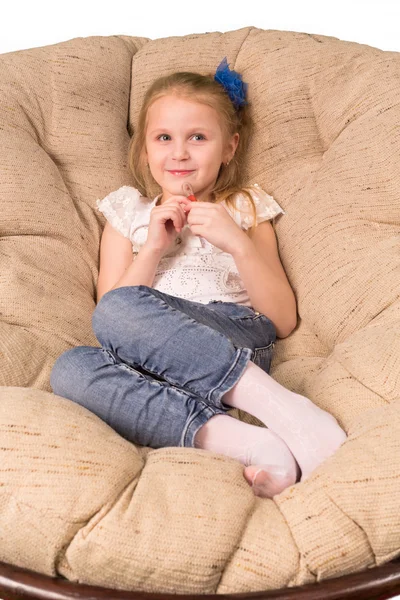 Beyaz arka plan üzerinde izole koltuğa oturan küçük kız — Stok fotoğraf