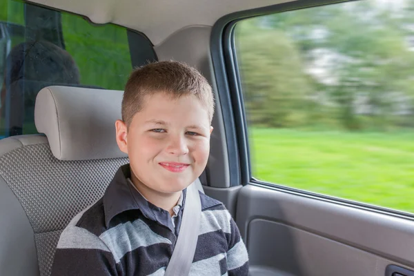 Tiener zittend in een auto in veiligheid stoel — Stockfoto