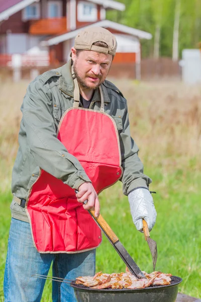 Muž připravuje barbecue na trávníku bbq — Stock fotografie