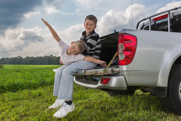 Twee broers siiting op een auto kofferbak — Stockfoto