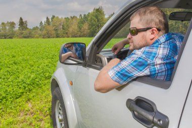 Arabada oturan adam.