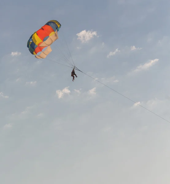 Люди на парашюте над морем — стоковое фото