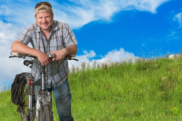 Homem turístico de pé com uma bicicleta em um planalto — Fotografia de Stock