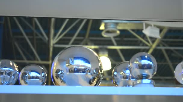 Bolas de aço de prata de diferentes tamanhos colocados em uma fileira na prateleira — Vídeo de Stock