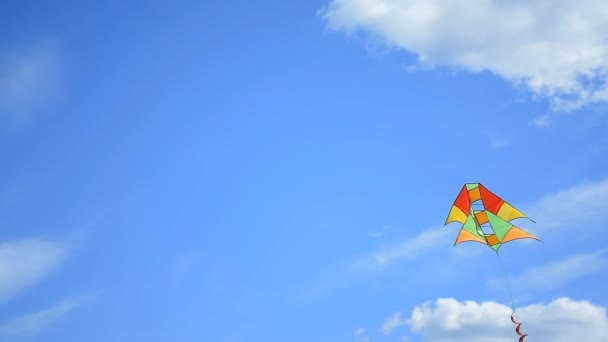 Цветной змей, летящий в голубом небе с облаками — стоковое видео