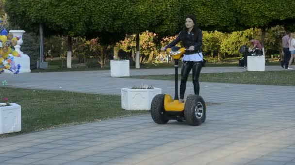 Una giovane donna attraente che cammina con scooter elettrico — Video Stock