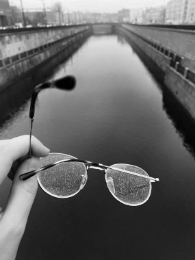 Arka planda yağmur damlaları olan su bardakları..