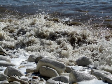 Küçük dalgalar sahile üstünde-e doğru gürültüyle çarpmak