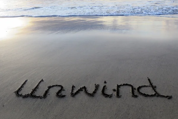 Unwind written in sand — Stock Photo, Image
