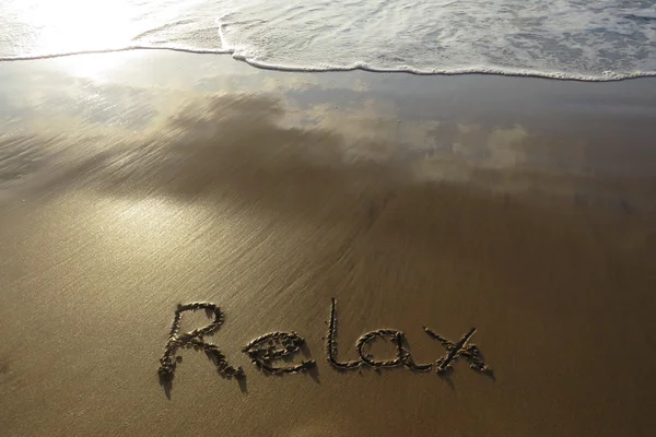 Relaxe escrito na areia — Fotografia de Stock