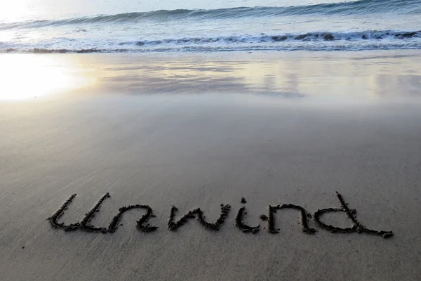 Unwind written in sand — Stock Photo, Image