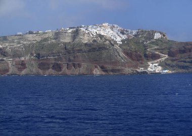 Santorini adasının beyaz binaları mavi Ege denizi ve mavimsi manzaralı 