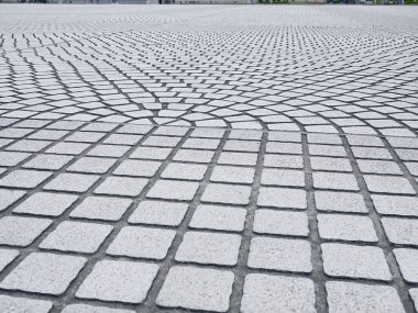 Soyut kentsel zemin arka planı. Gri taştan bir geçitin dokusu tekrarlanan fan şeklindeki kaldırım taşı desenini içeriyor. Dayanıklı yaya kaldırımının perspektif görüntüsü.