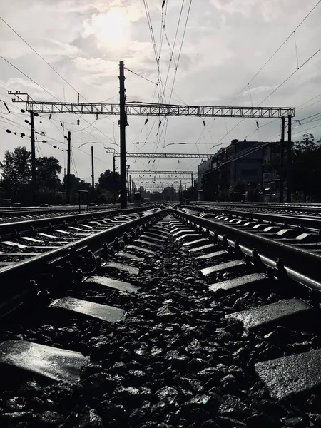 在多雨的夏日 有云彩和阳光 用岩石看潮湿的铁路 — 图库照片