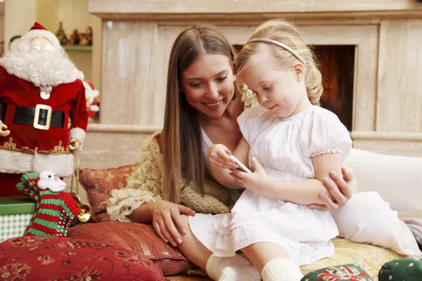 Mother and daughter by fireplace — Stock Photo, Image