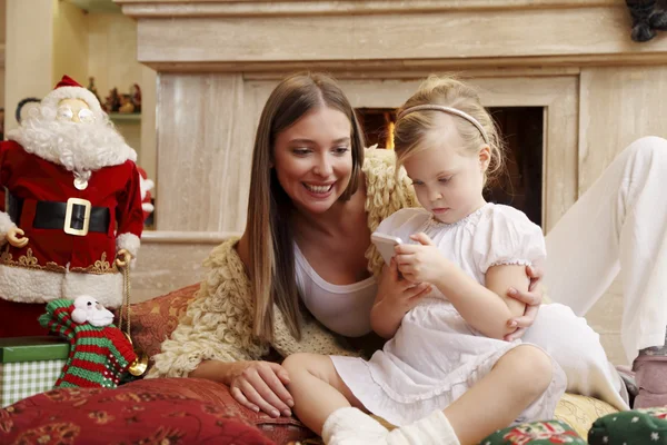 Mother and daughter by fireplace — Stock Photo, Image