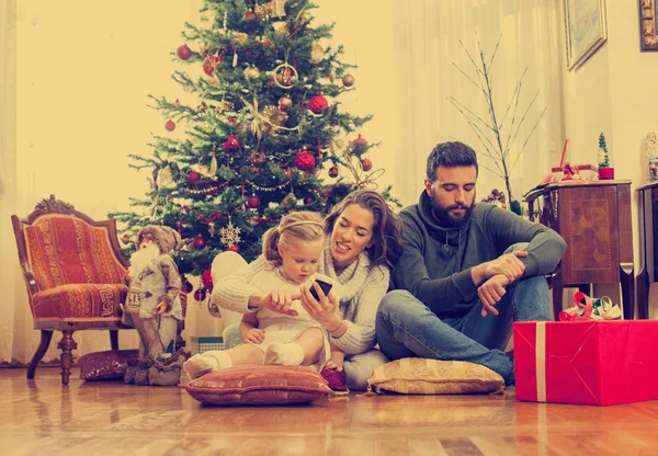 Família feliz na frente da árvore de Natal — Fotografia de Stock