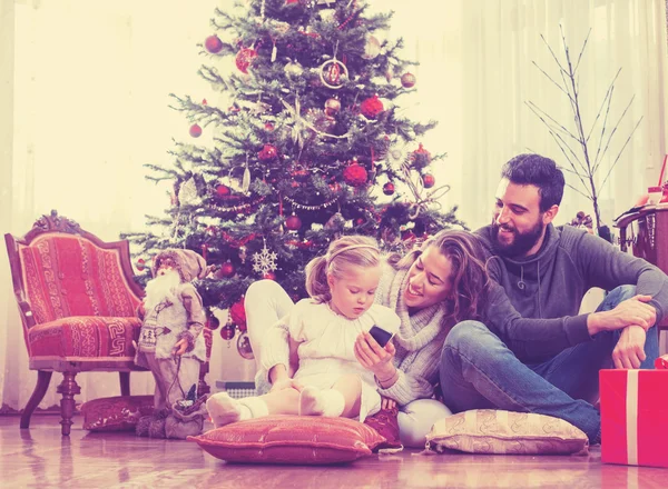 Família feliz na frente da árvore de Natal — Fotografia de Stock