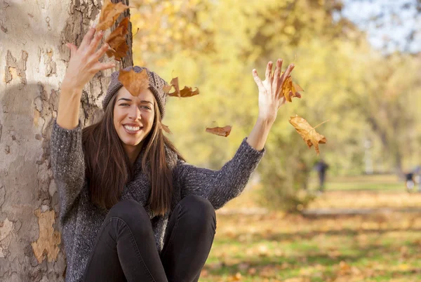 Femeia renunță la frunze în parcul de toamnă — Fotografie, imagine de stoc