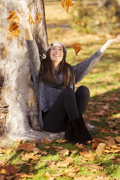 Mulher cai folhas no parque de outono — Fotografia de Stock