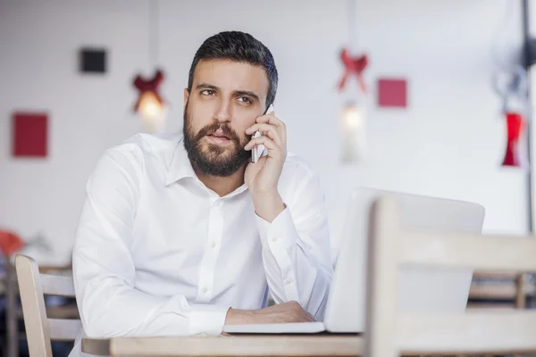 Businessman talking on phone in restaurant — Stock Photo, Image